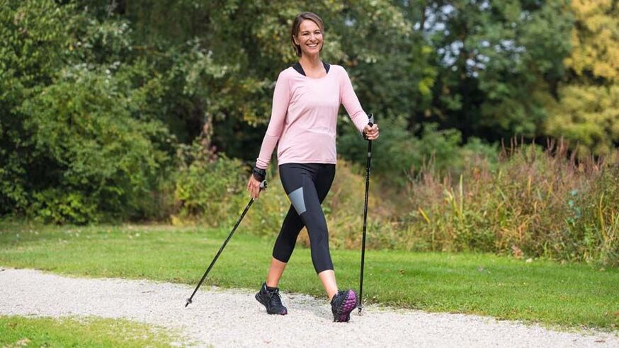 eine Frau geht spazieren, um Rückenschmerzen vorzubeugen